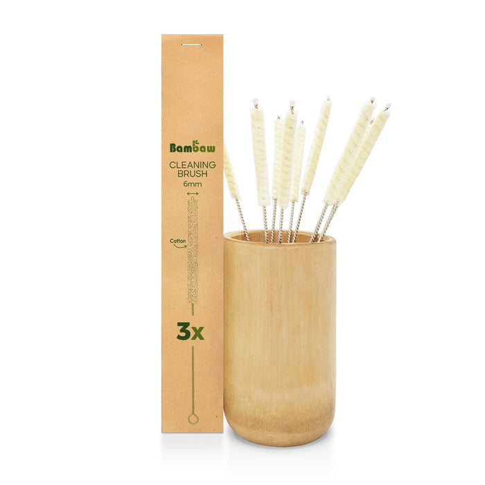 Cotton straw cleaning brushes arranged in a bamboo holder beside the tall cardboard packaging.
