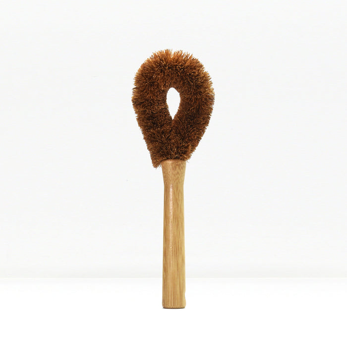 Brown fluffy dish brush with wooden handle on a white background