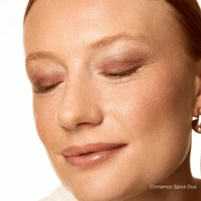 Close-up of a woman's face with closed eyes, wearing makeup with 'Cinnamon Spice Duo' color.