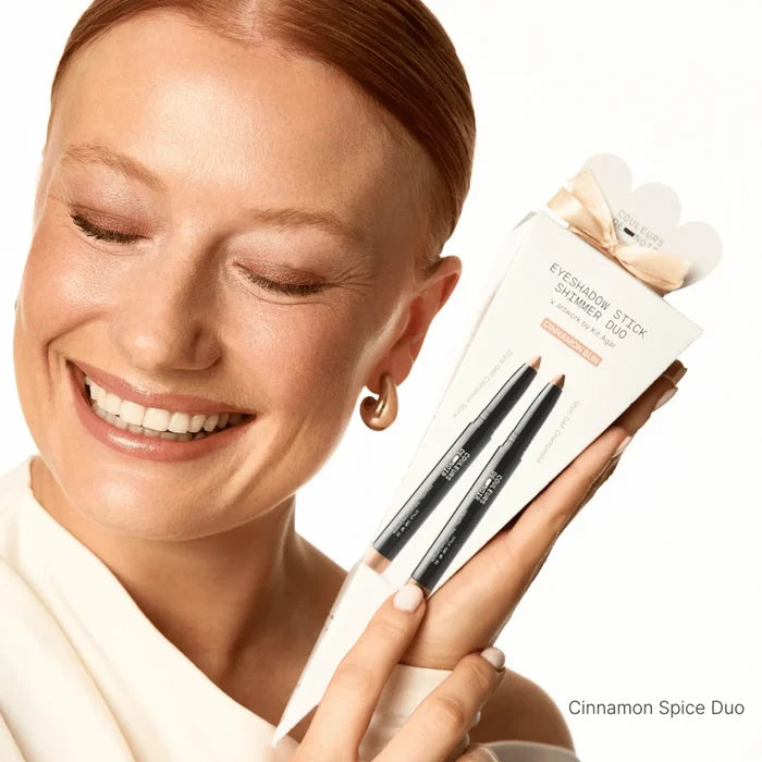 Woman holding a makeup product packaging with 'Cinnamon Spice Duo' text.