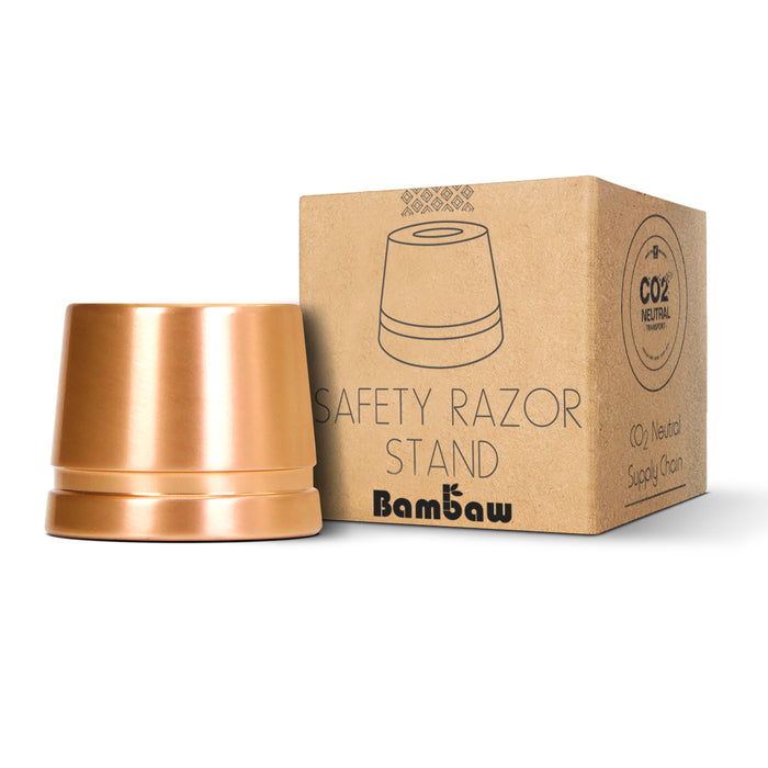 Copper safety razor stand beside a Bambaw cardboard box with bamboo graphics