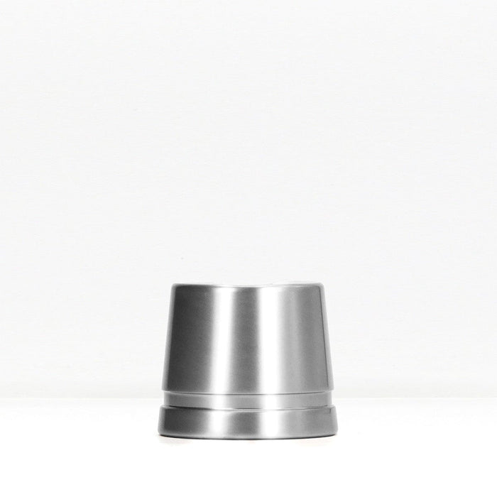 Polished silver metal safety razor stand on a white surface.