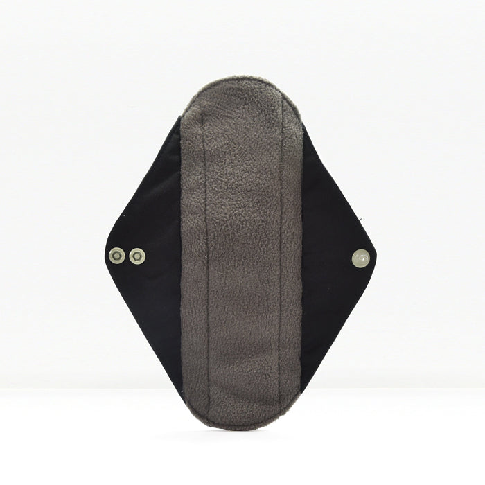 Close-up of a grey fabric reusable sanitary pad with black wings on a white background