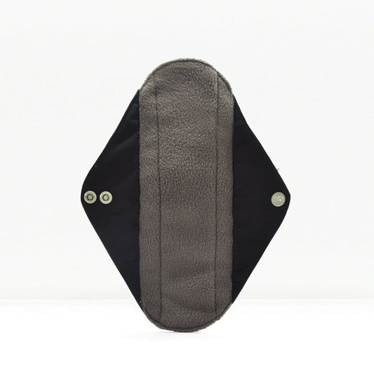 Close-up of a grey fabric reusable sanitary pad with black wings on a white background